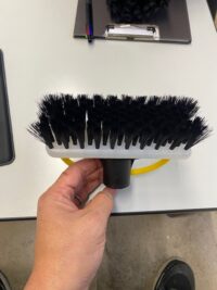 黒い毛を持つ多用途に適した工業用ブラシ、グレーと黄色のハンドルが特徴的で効率的な洗浄を実現